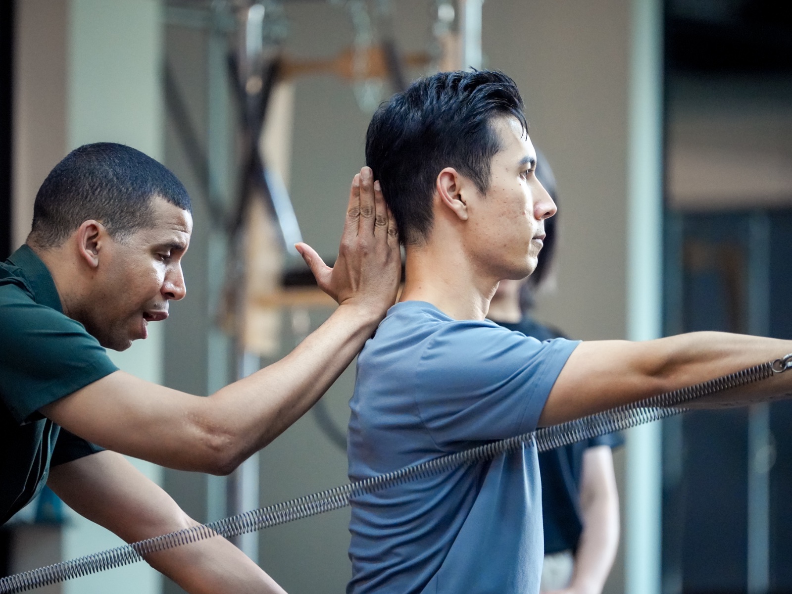 Hands placing feet on Reformer footbar — close-up detail