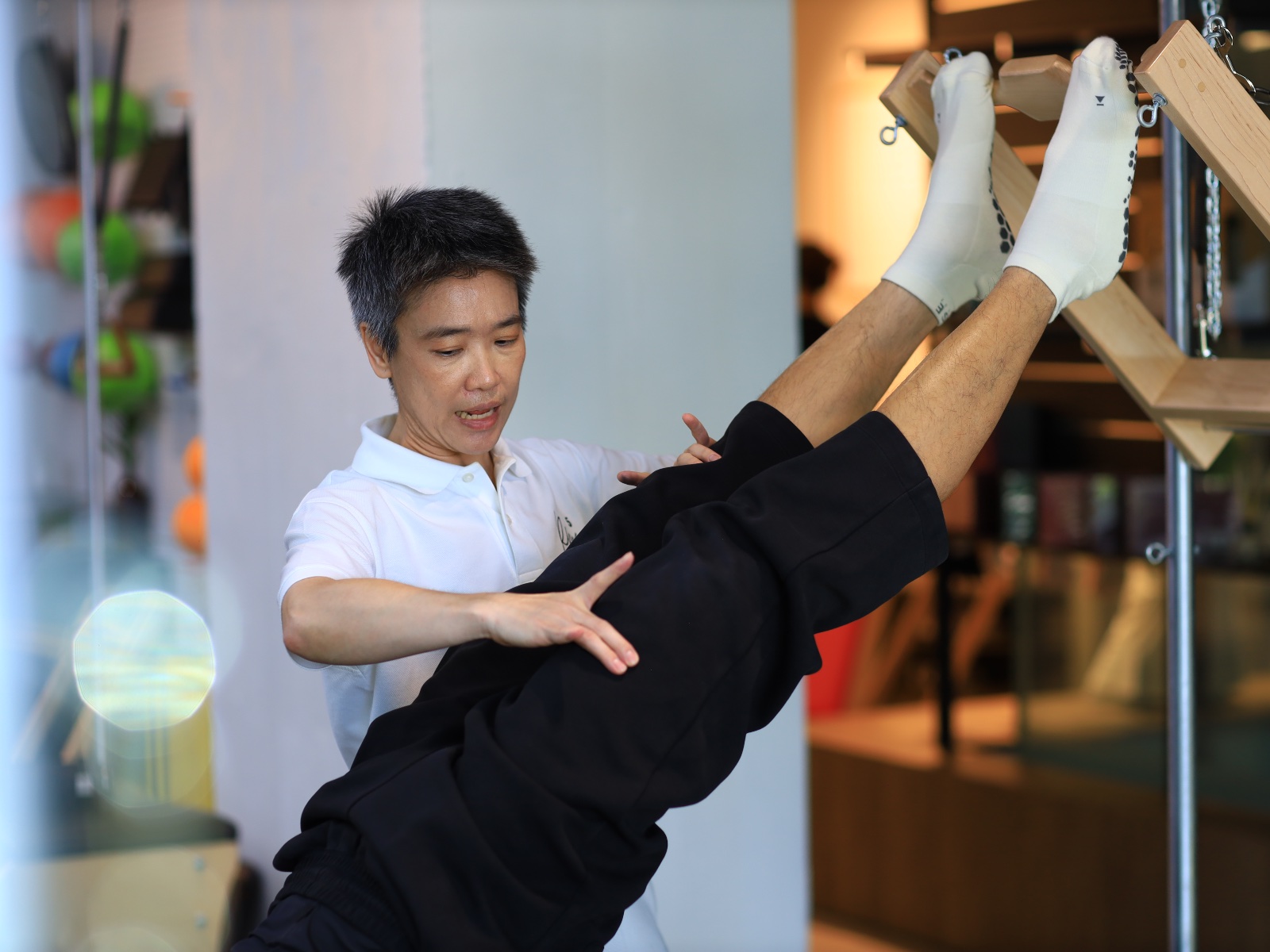 Kru Mai guiding a student on the apparatus